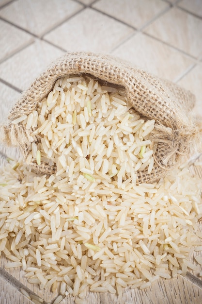 Arroz de jasmim da tailândia em sacos com fundo de madeira