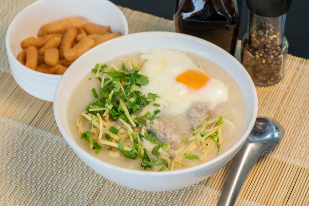 Arroz de papas de aveia com ovo em tigela branca Café da manhã tradicional chinês com palito de massa frita