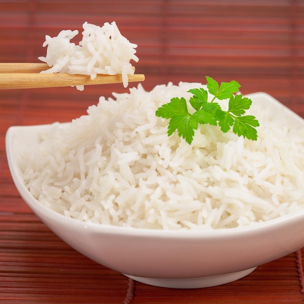 Arroz do Japão com pauzinhos em uma esteira de bambu