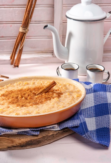 Arroz doce com canela em uma tigela marrom em ambiente rústico.