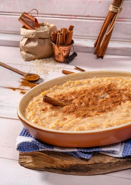 Arroz doce com canela em uma tigela marrom em ambiente rústico.