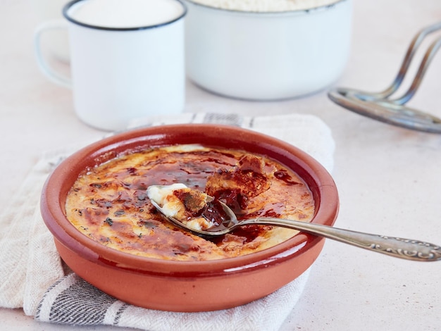 Arroz doce cremoso à moda asturiana Ingredientes para a preparação de receitas e uma porção pronta a comer com crosta de açúcar caramelizado