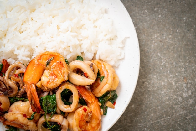 Foto arroz e frutos do mar fritos (camarões e lulas) com manjericão tailandês - comida asiática