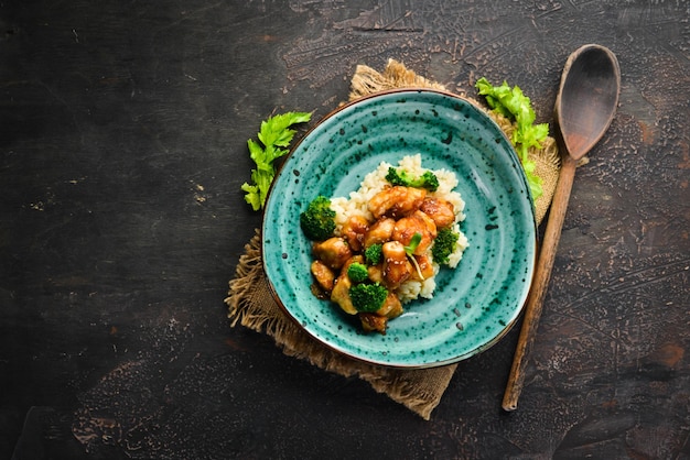 Arroz con filete de pollo y brócoli. Cocina tailandesa. en el plato Vista superior. Espacio libre para su texto. Estilo rústico.