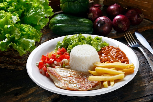 Arroz, frijoles, carne, patatas fritas y ensalada.