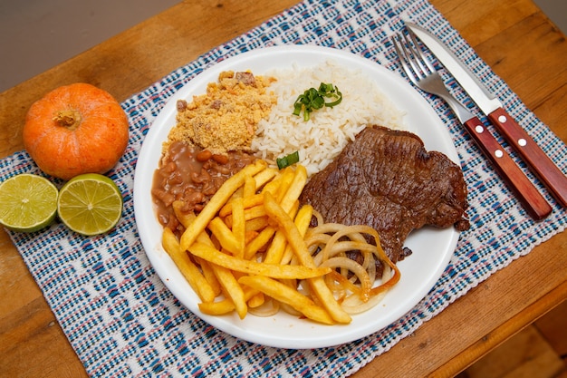 Arroz, frijoles, papas fritas y filete de ternera