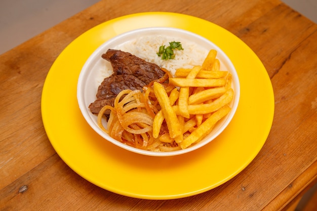 Arroz, frijoles, papas fritas y filete de ternera