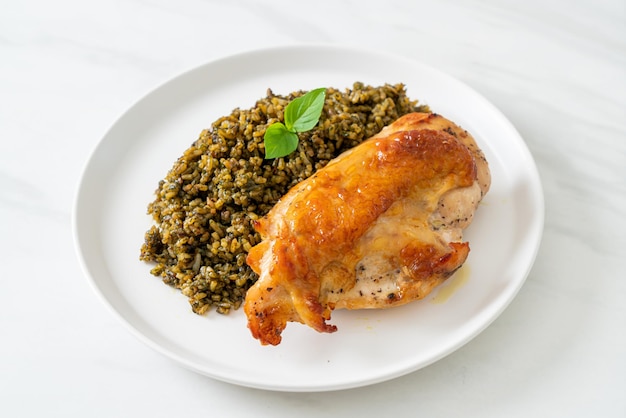 arroz frito al pesto con pollo asado en plato blanco