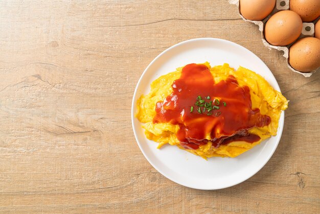 Arroz frito aromatizado en una envoltura de tortilla u Omurice al estilo japonés de comida asiática