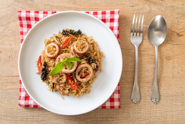 Arroz frito casero con albahaca y hierbas picantes con calamar o pulpo - estilo de comida asiática