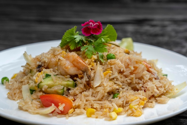 Arroz frito com camarões e legumes em um prato branco em uma velha mesa de madeira fechar comida tailandesa cozinha tailandesa