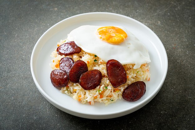 Arroz frito com ovo frito e linguiça chinesa - comida caseira em estilo asiático