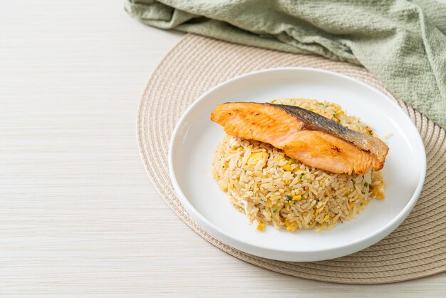 arroz frito con filete de salmón a la parrilla en plato blanco