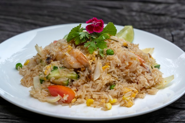 Arroz frito con gambas y verduras en un plato blanco sobre una mesa de madera antigua cerrar comida tailandesa cocina tailandesa