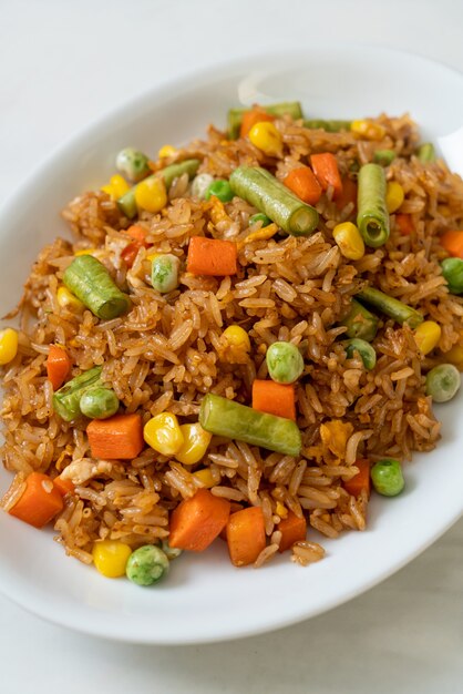 Foto arroz frito con guisantes, zanahoria y maíz - estilo de comida vegetariana y saludable
