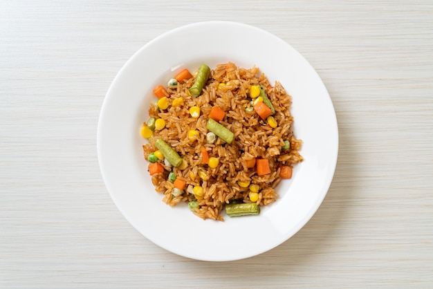 arroz frito con guisantes, zanahoria y maíz - estilo de comida vegetariana y saludable