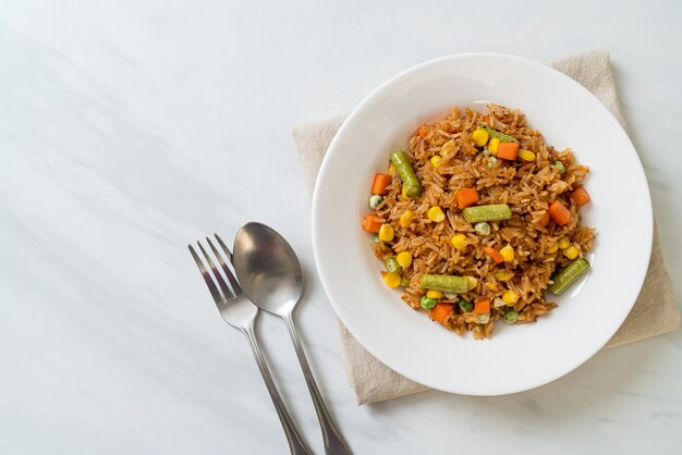 arroz frito con guisantes, zanahoria y maíz - estilo de comida vegetariana y saludable