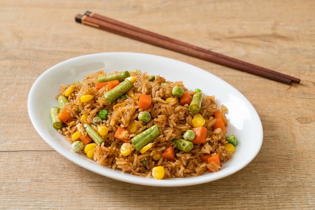 arroz frito con guisantes, zanahoria y maíz - estilo de comida vegetariana y saludable