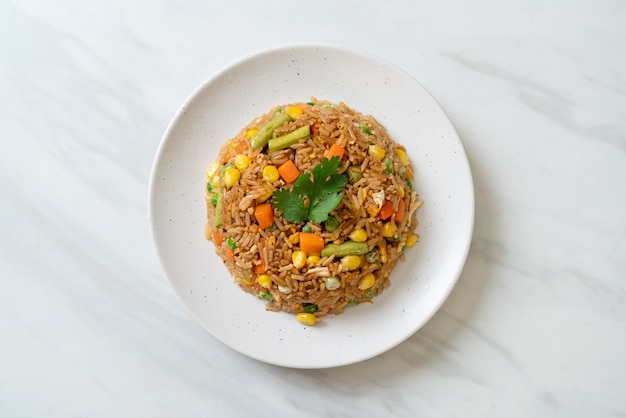 Arroz frito con guisantes, zanahoria y maíz - estilo de comida vegetariana y saludable