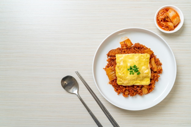 arroz frito con kimchi con cerdo y queso cubierto - estilo de comida asiática y fusión