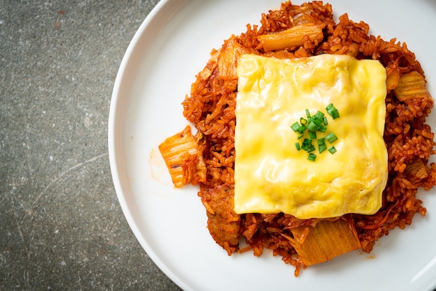 arroz frito con kimchi con cerdo y queso cubierto - estilo de comida asiática y fusión