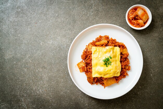 arroz frito con kimchi con cerdo y queso cubierto - estilo de comida asiática y fusión