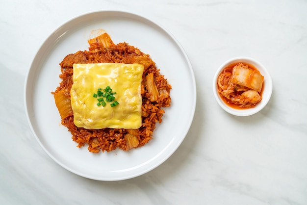 arroz frito con kimchi con cerdo y queso cubierto - estilo de comida asiática y fusión