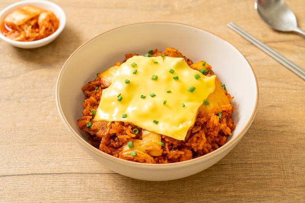 arroz frito con kimchi con cerdo y queso cubierto - estilo de comida asiática y fusión