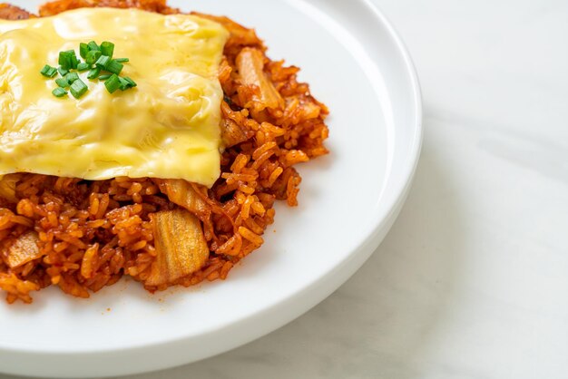 arroz frito con kimchi con cerdo y queso cubierto - estilo de comida asiática y fusión