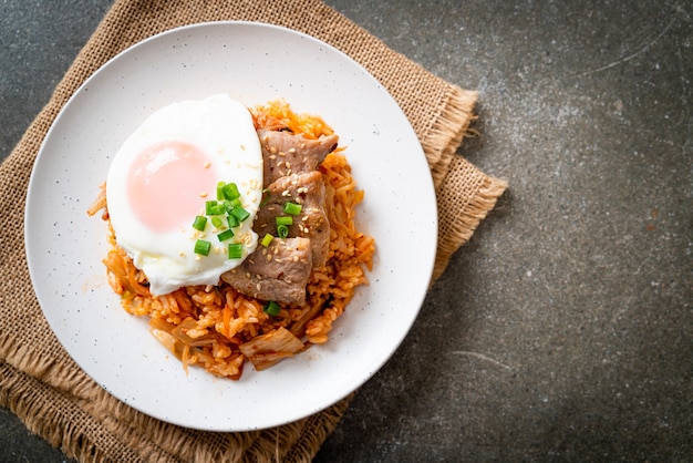 Arroz frito kimchi com ovo frito e carne de porco - comida coreana