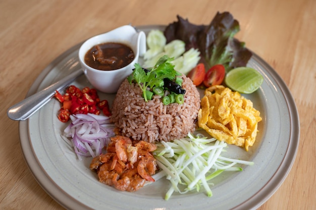 El arroz frito mezclado con pasta de gambas con hierbas de cerdo marinadas y verduras es comida tradicional tailandesa