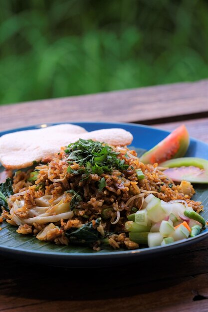 Arroz frito en un plato azul Galletas saladas de pepino y zanahoria Arroz frito con verduras de res y galletas de camarones en un plato azul El plato