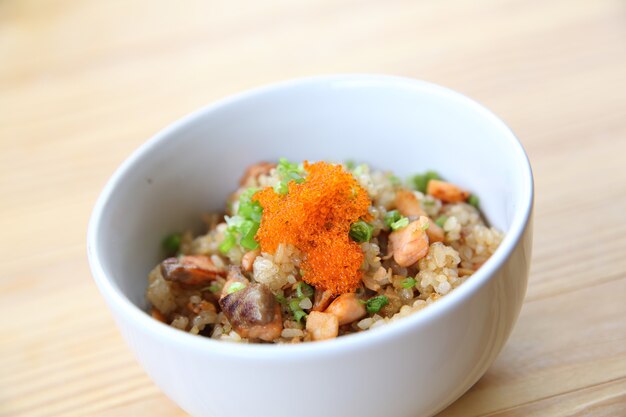 Arroz frito con salmón japonés sobre fondo de madera