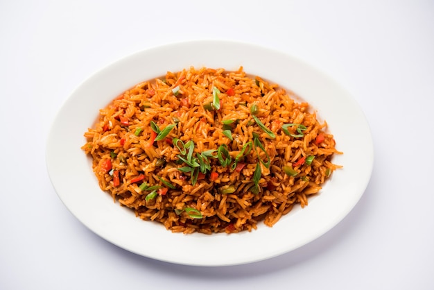 El arroz frito Schezwan Masala es una comida indochina popular que se sirve en un plato o tazón con palillos. enfoque selectivo