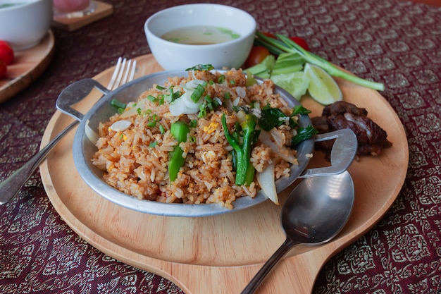 Arroz frito tailandês em uma tábua de madeira