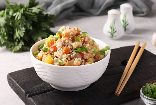 arroz frito con verduras, ajo, jengibre y cebolla verde sobre fondo gris. cocina asiática