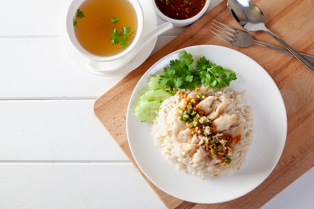 Arroz hainanés, pollo al vapor con arroz, Khao Mun Kai sobre fondo de madera