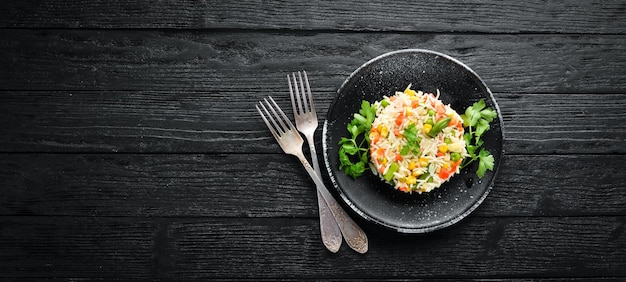 Arroz hervido y risotto de verduras en un plato negro Vista superior Espacio de copia libre