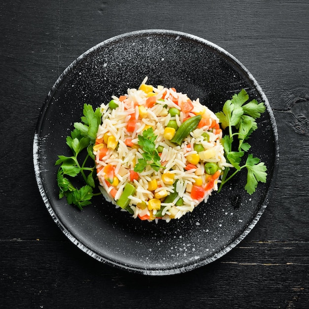Arroz hervido y risotto de verduras en un plato negro Vista superior Espacio de copia libre