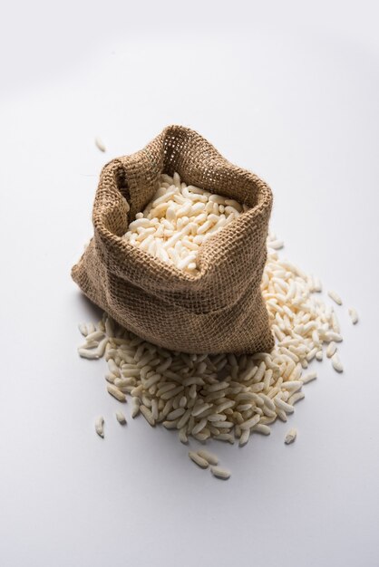 Arroz inflado indio o murmullo en bolsa de yute o tela, aislado sobre fondo blanco.