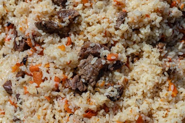 Arroz con ingredientes de pilaf plato culinario tradicional oriental con rodajas de carne grasa y verduras coche ...