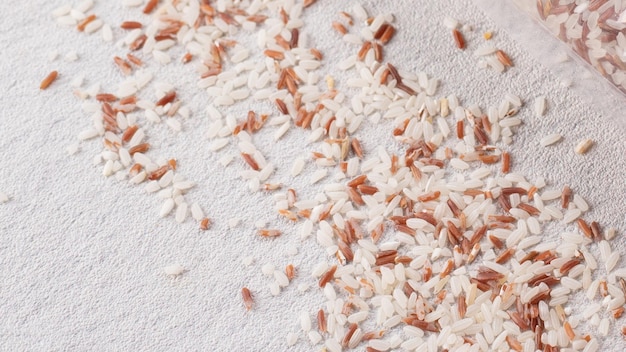 Arroz integral orgánico (beras merah) y arroz blanco en la mesa blanca
