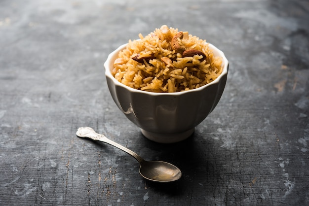 Arroz Jaggery tradicional ou Gur wale chawal em hindi, servido em uma tigela com colher. foco seletivo