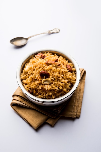 Arroz Jaggery tradicional ou Gur wale chawal em hindi, servido em uma tigela com colher. foco seletivo