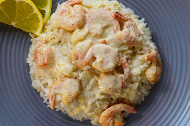 arroz con langostinos y limón en un plato gris