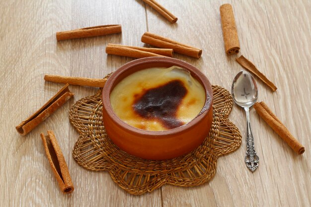 Arroz con leche al horno postre turco sutlac en cazuela de barro con palitos de canela