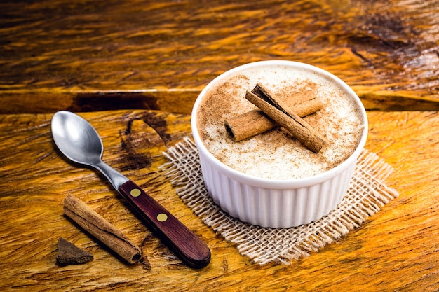 Arroz con leche cremoso espolvoreado con canela, postre típico brasileño.