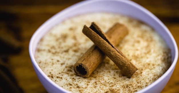 Arroz con leche cremoso espolvoreado con canela, postre típico brasileño.