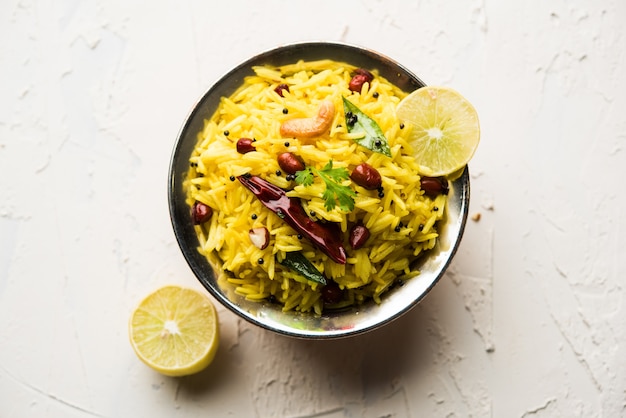 Arroz con limón o fodnicha bhat es arroz con cúrcuma del sur de la India o receta maharashtrian con arroz sobrante aderezado con hojas de curry de nueces y jugo de limón, enfoque selectivo