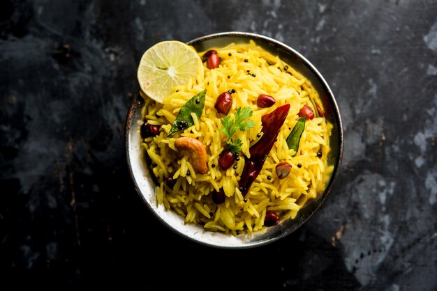 Arroz con limón o fodnicha bhat es arroz con cúrcuma del sur de la India o receta maharashtrian con arroz sobrante aderezado con hojas de curry de nueces y jugo de limón, enfoque selectivo